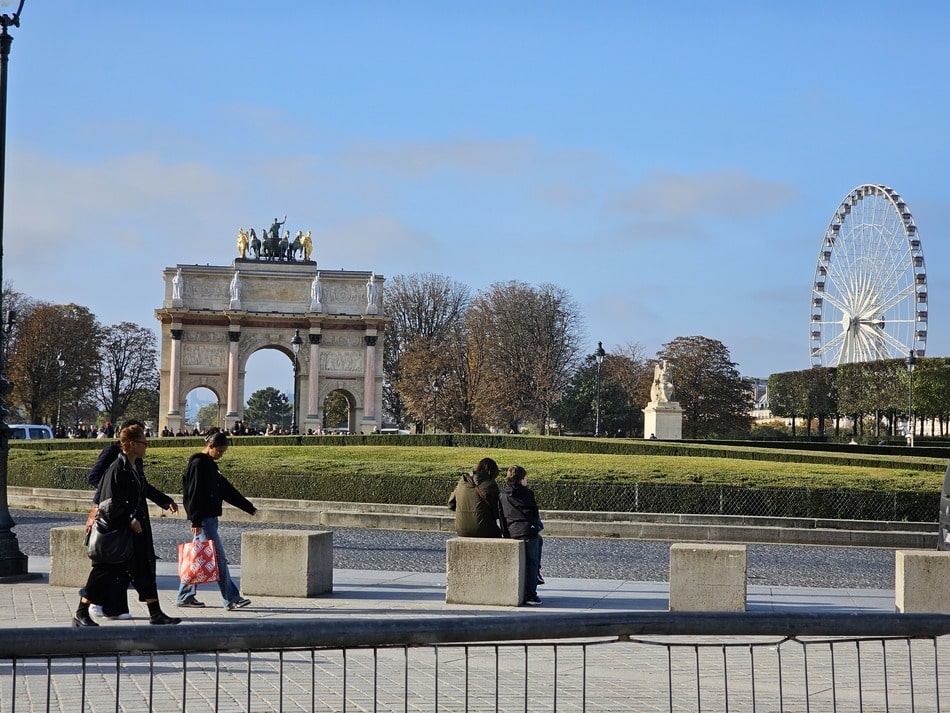 passants devant l'Arc de Triomphe du Carrousel