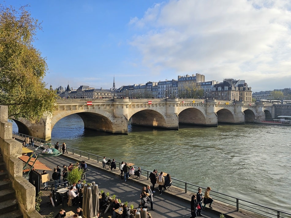 gens qui marchent sur la promenade face au Pont Neuf de la Seine