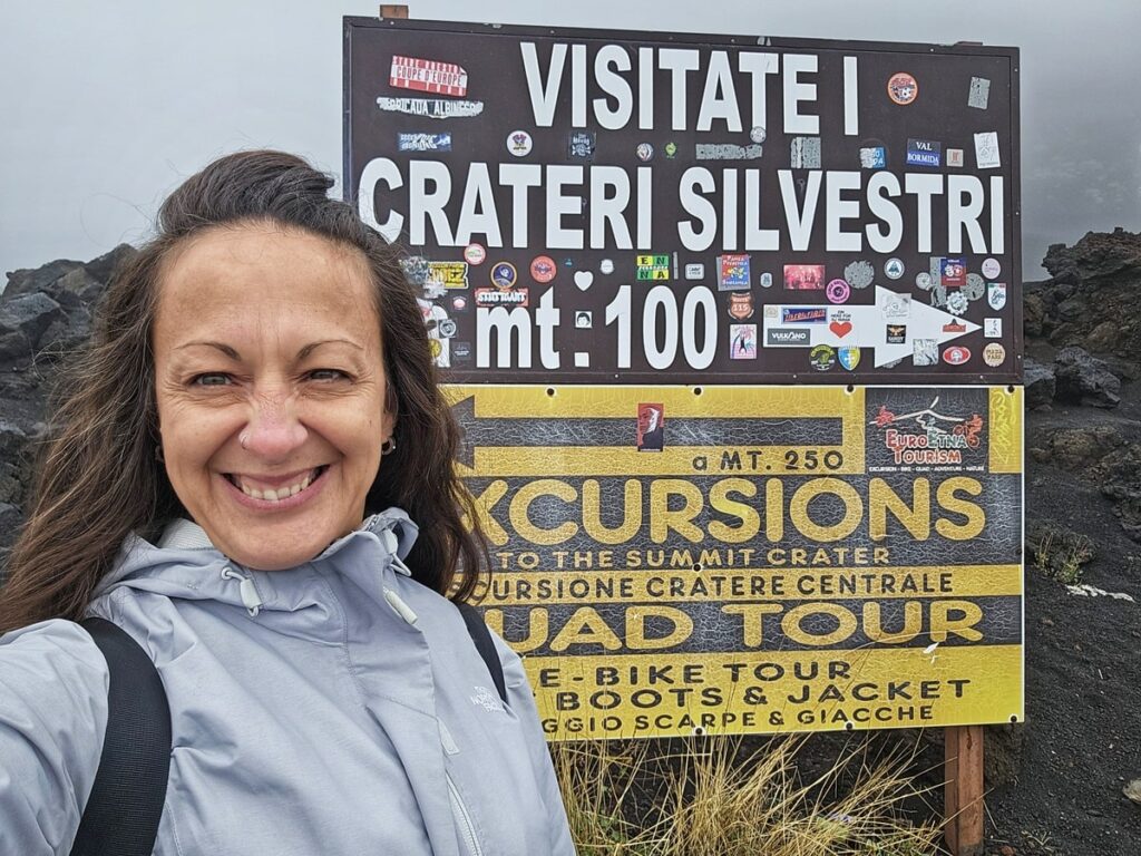 Moi devant la pancarte avec les détails du volcan dans mon article de voyage Grimper l'Etna : Mon expérience volcanique en Sicile #italie #sicile #etna #volcan