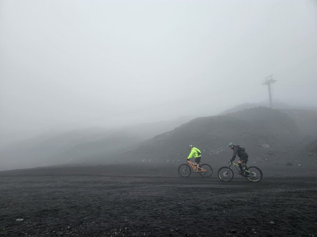 2 cyclistes qui pédalent sur la cendre du volcan