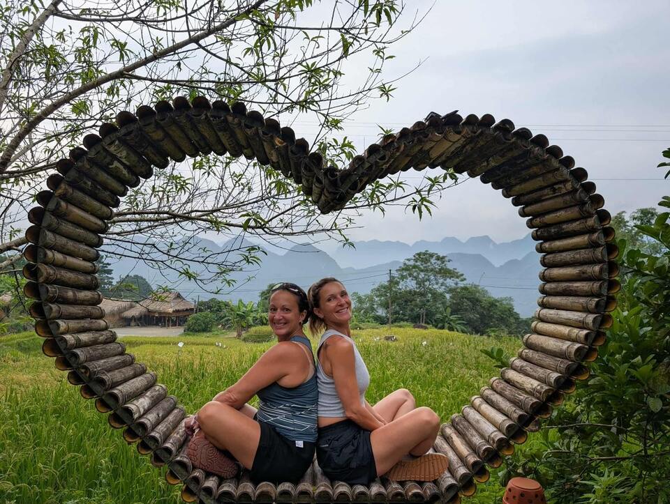 Ma soeur et moi à l'intérieur d'un coeur en bois avec une vue sur les montagnes du nord du Vietnam