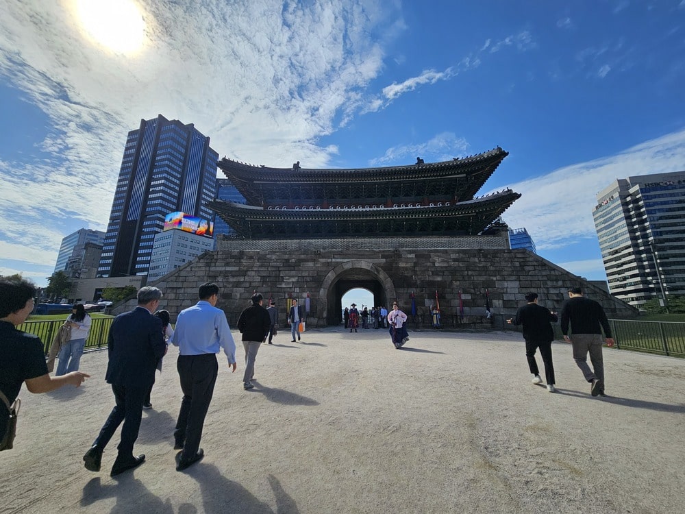 Porte Sungnyemun à Séoul, un monument historique devant des bâtiments modernes en verre et acier.