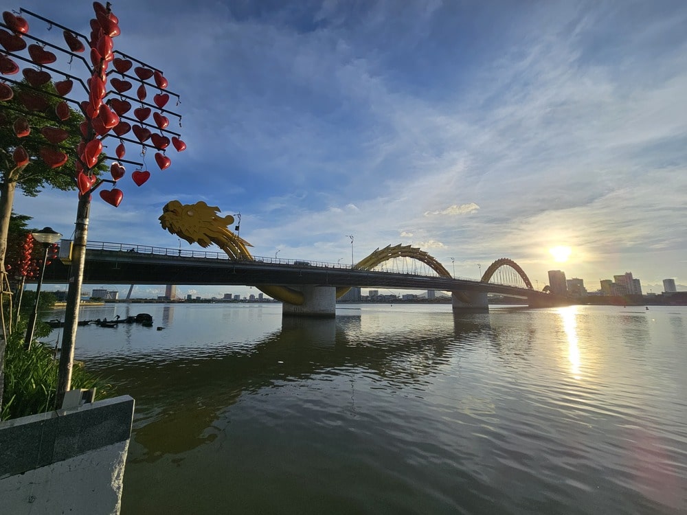 Pont avec un dragon jaune comme structure, lors du coucher du soleil, à Danang