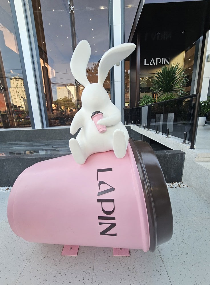 Décoration d'un lapin blanc assis sur un verre de café rose, symbole du restaurant Lapin à Danang, un incontournable à voir lors d'un voyage au Vietnam