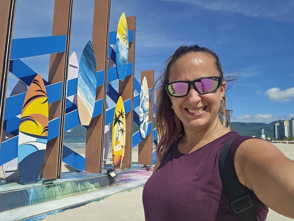 Je suis devant une décoration de plage avec un montage de planches de surfs, à Danang, sur la plage de My Khe, lors de mon séjour au Vietnam
